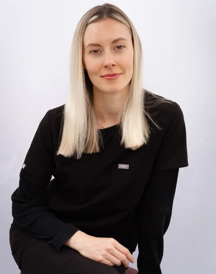 Blonde woman touching the sides of her face