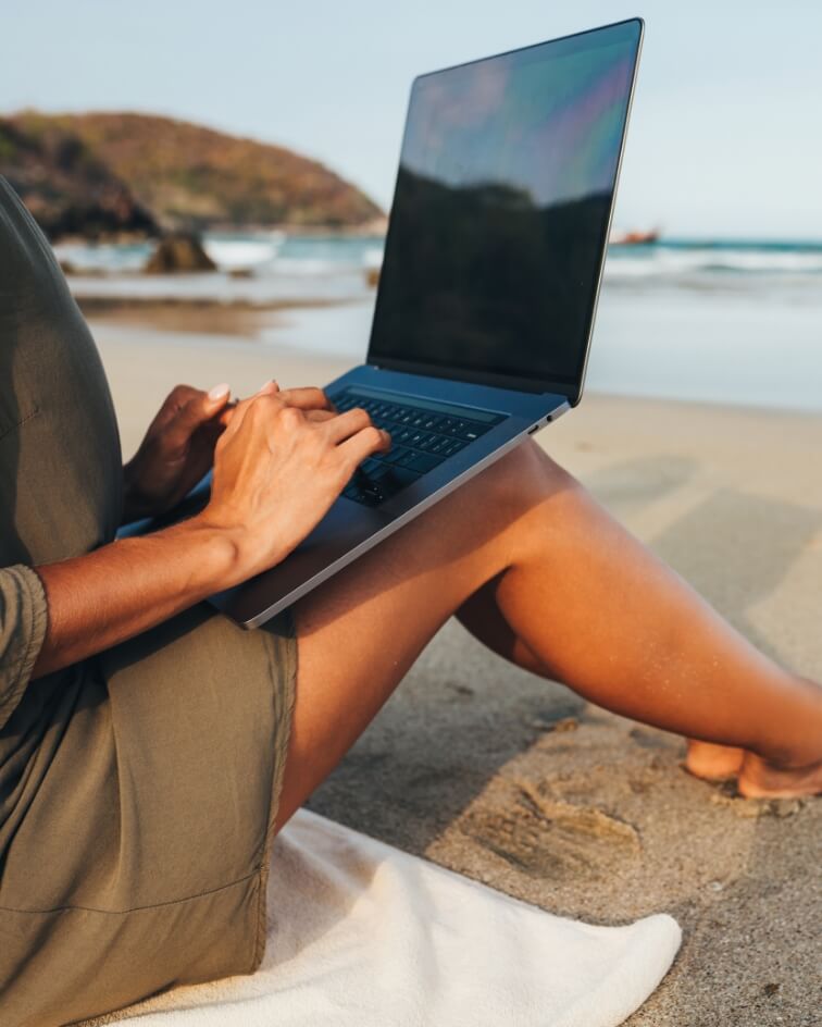 Woman using a laptop at the beach