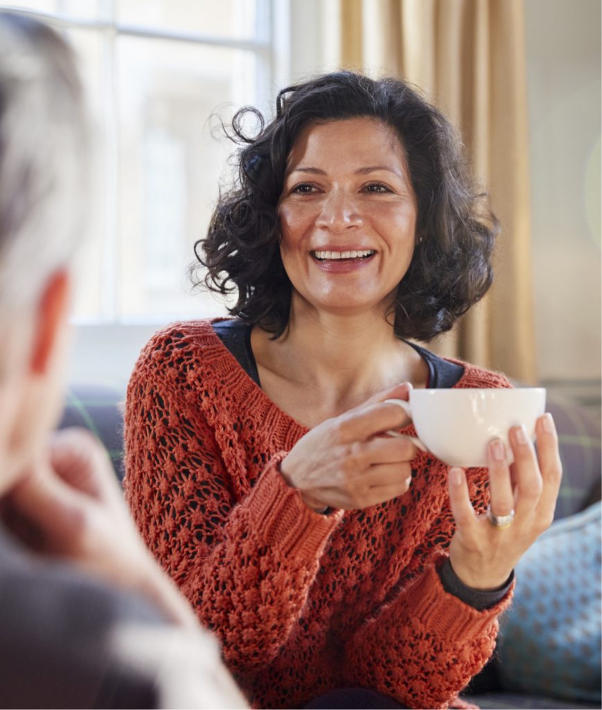 Woman in a red sweater holding a tea cup
