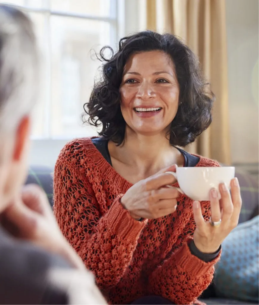 Woman in a red sweater holding a tea cup