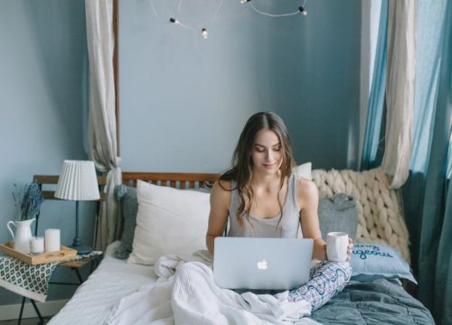 Woman on a laptop in her bedroom