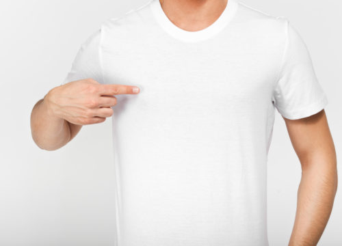 Man in a white t-shirt pointing at his pectorals