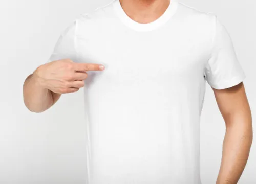 Man in a white t-shirt pointing at his pectorals