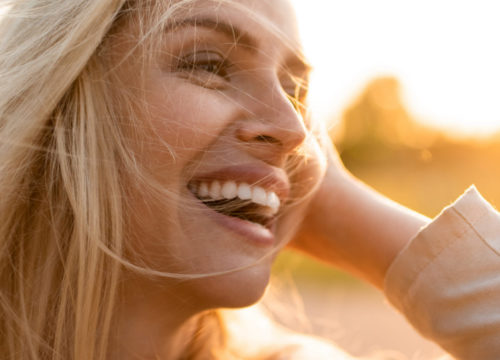 Woman smiling outside during a sunset