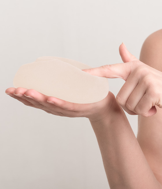 Woman pointing at a breast implant