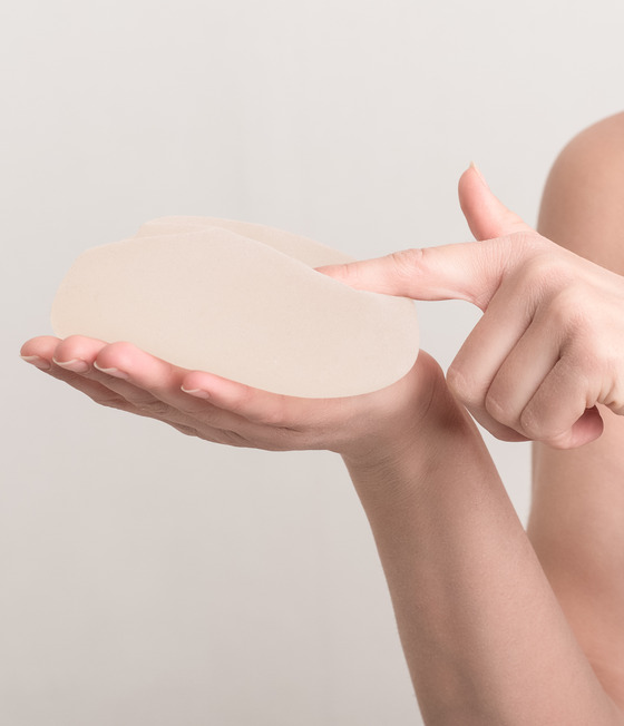 Woman pointing at a breast implant