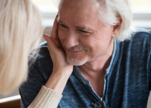 A woman placing her hand on a man's cheek