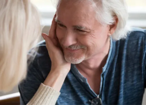A woman placing her hand on a man's cheek